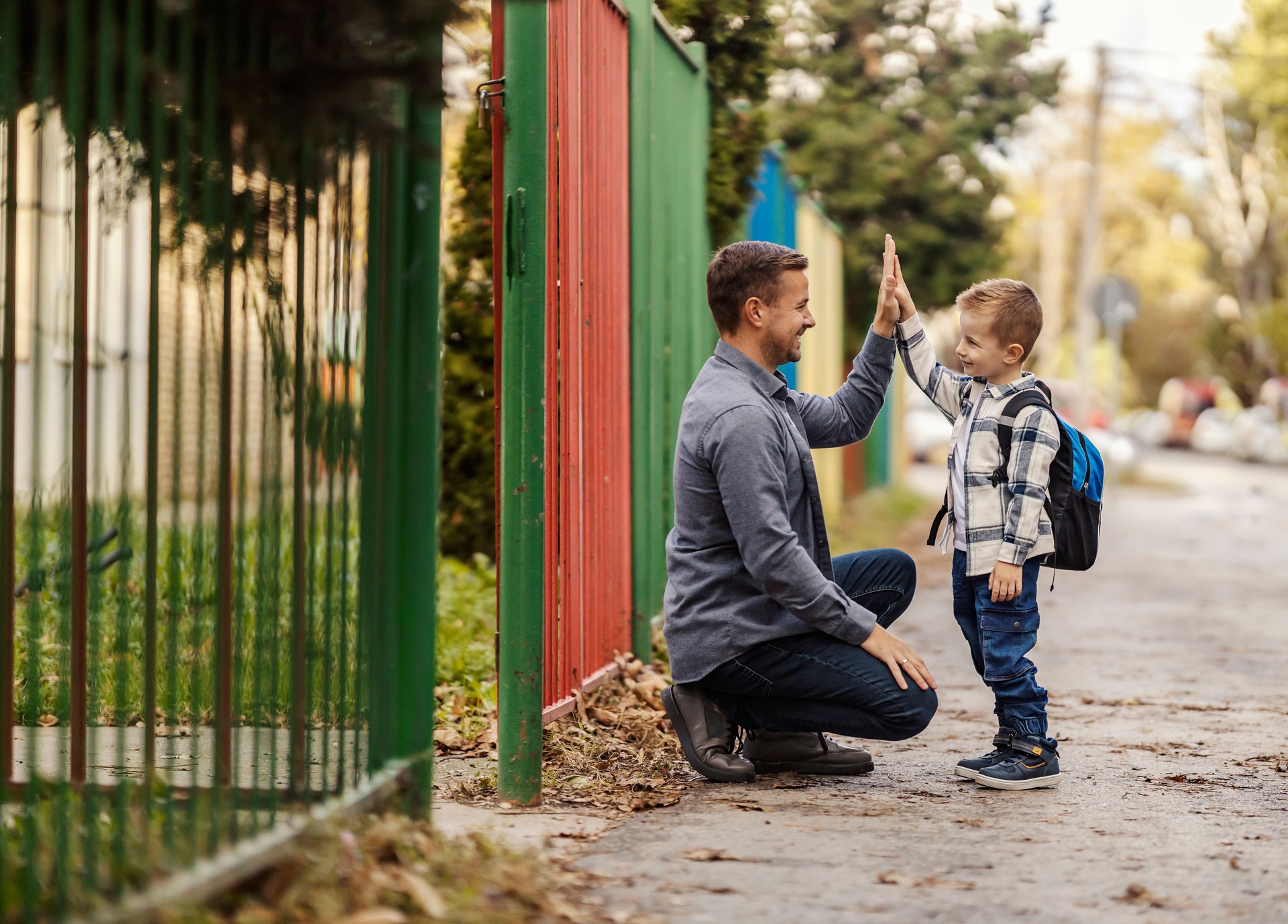 A father and song giving high five on the entrance of kindergarten.